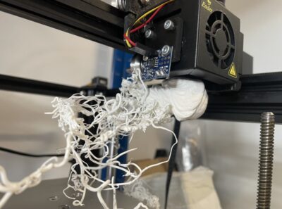 Another example of 3D printing gone wrong: a white filament blob is still attached to the extruder.